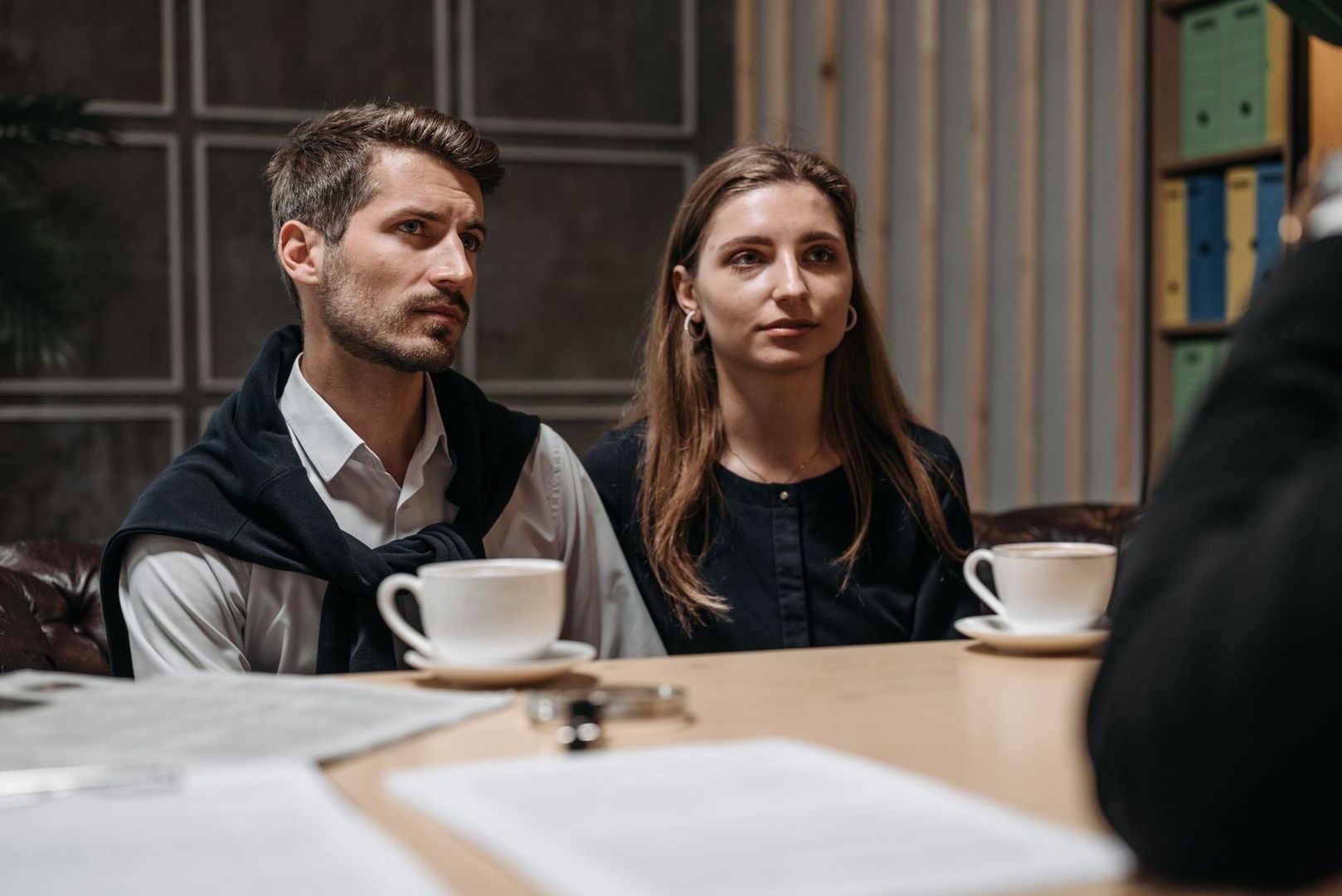 Två personer i ett möte vid ett bord med kaffekoppar
